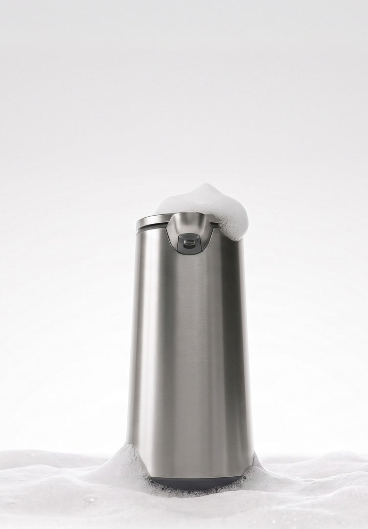 Simplehuman Sensor Pump Foam in brushed stainless steel, surrounded by white soap foam with a dollop resting on top.